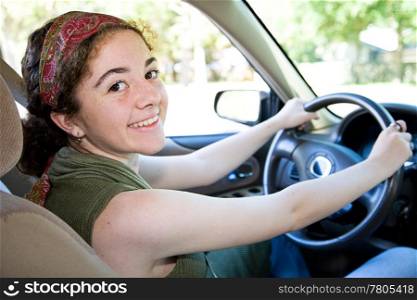 Beautiful, confident teen girl behind the wheel of her car.