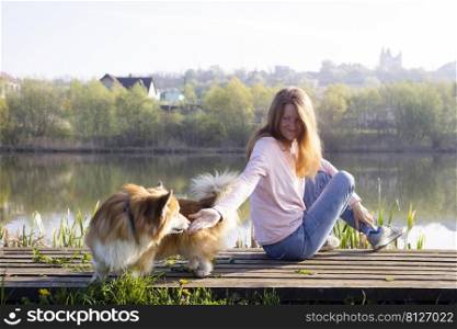 beautiful corgi dog and girl on the lake 