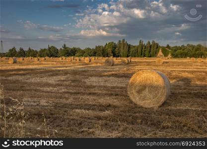 Beautiful Countryside Landscape: Round Hay Bales in Harvested Fields and Blue Sky with Clouds