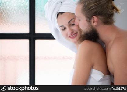 Beautiful couple in love enjoying morning in the bathroom. Man and woman with towels on their heads