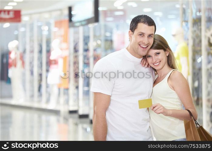 Beautiful couple in the store with credit card