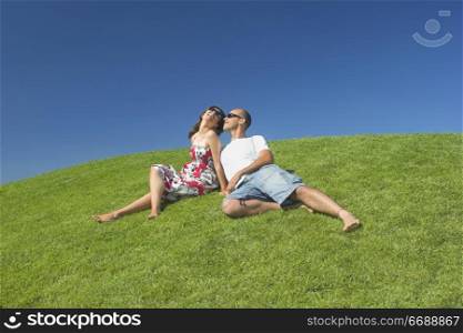 Beautiful couple of boyfriends relaxing on a beautiful green field