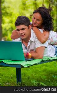 beautiful couple on bench with laptop
