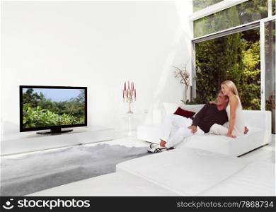 Beautiful Couple Sitting On Couch Watching TV
