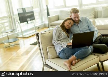 Beautiful couple sitting on the floor with laptop in the living room