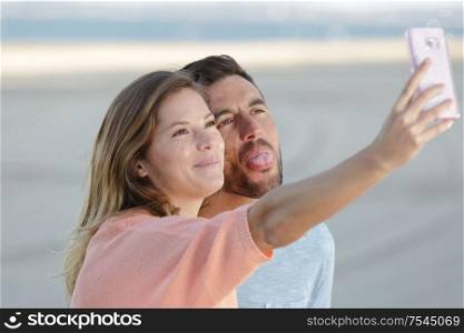 beautiful couple taking a selfie photo on white background