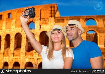 Beautiful couple taking picture of them self on Coliseum background, happy young family spending summer vacation in Rome, Italy, Europe
