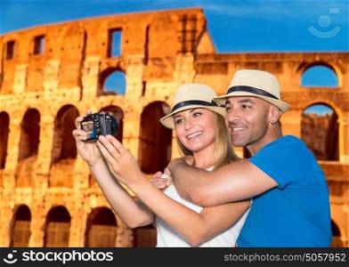 Beautiful couple taking picture of themself on Coliseum background, happy young family spending summer vacation in Rome, Italy, Europe