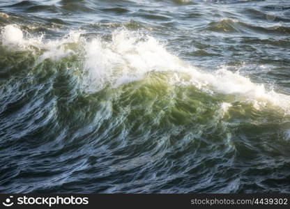 Beautiful crest of ocean wave crashing at sunset