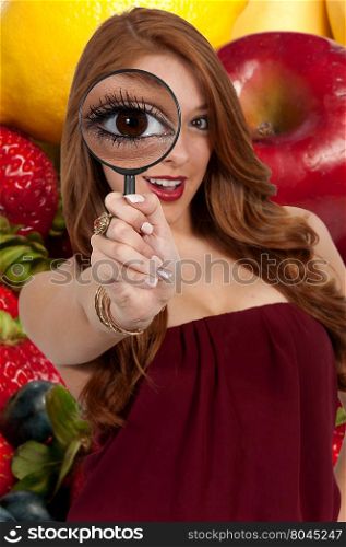 Beautiful curious woman looking through a magnifying glass