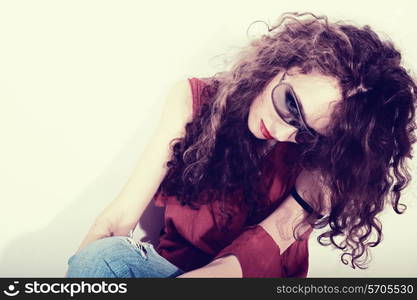 beautiful curly brunette woman in red T-shirt and blue jeans on white backgroun