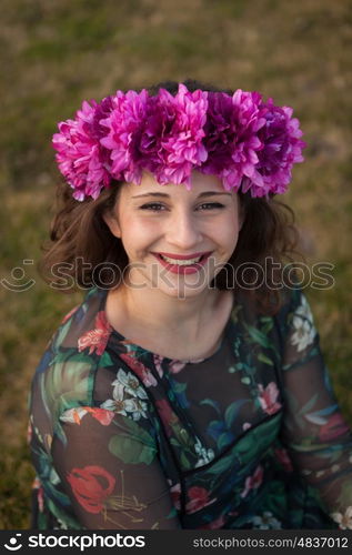 Beautiful curvy girl with a flower crown in the landscape