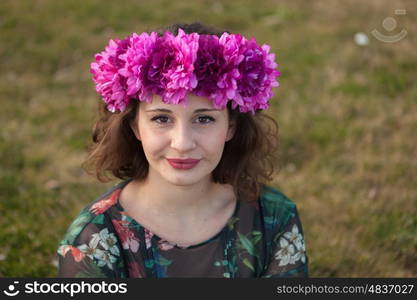 Beautiful curvy girl with a flower crown in the landscape