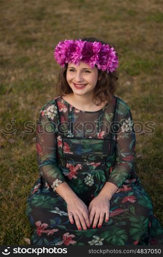 Beautiful curvy girl with a flower crown in the landscape