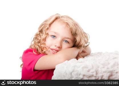 Beautiful cute happy smiling girl with blue eyes daydreaming laying on soft surface, isolated.