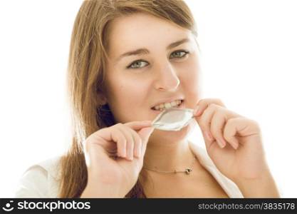 Beautiful cute woman holding condom in mouth