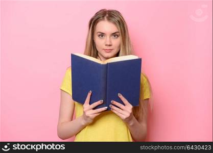 Beautiful cute woman reading book isolated on pink background