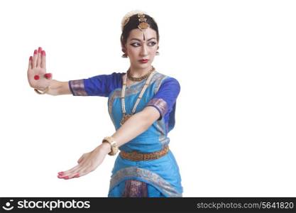 Beautiful dancer performing Bharatanatyam against white background