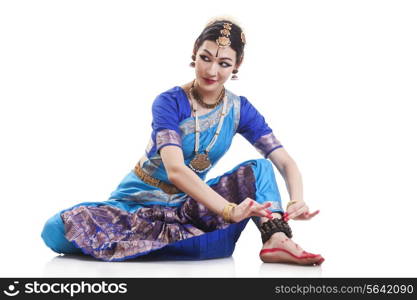 Beautiful dancer performing Bharatanatyam against white background