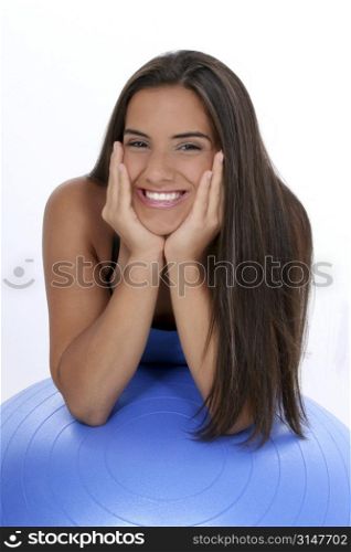 Beautiful dark haired tan teen girl in workout clothes leaning on excercise ball.