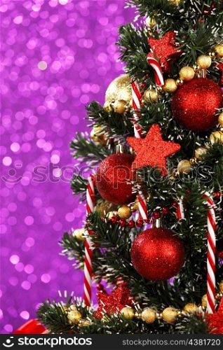 Beautiful decorated Christmas tree on glitter background