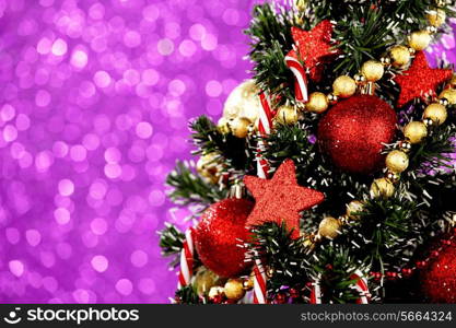 Beautiful decorated christmas tree on glitter purple background