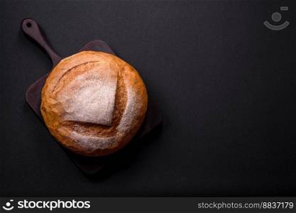 Beautiful delicious freshly baked round shaped white bread on a dark concrete background