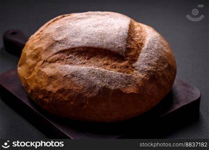 Beautiful delicious freshly baked round shaped white bread on a dark concrete background