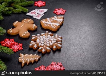 Beautiful delicious gingerbread gingerbread with Christmas tree branches on a dark concrete background. Preparing decorations for the Christmas table. Beautiful delicious gingerbread gingerbread with Christmas tree branches