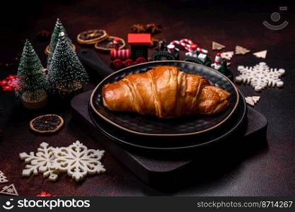Beautiful different Christmas decorations and croissant on a brown concrete table. Preparation for New Year&rsquo;s celebrations. Beautiful different Christmas decorations and croissant on a brown concrete table