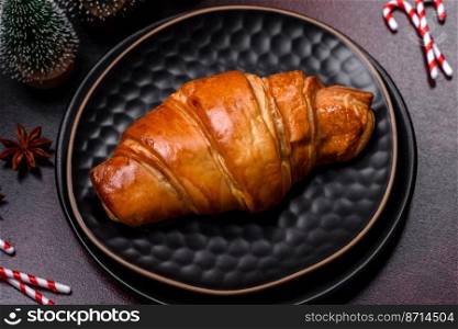 Beautiful different Christmas decorations and croissant on a brown concrete table. Preparation for New Year&rsquo;s celebrations. Beautiful different Christmas decorations and croissant on a brown concrete table