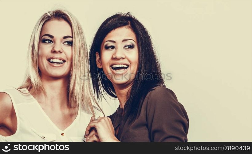Beautiful different race women friends black and white girls having fun smiling studio shot