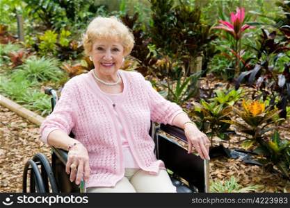Beautiful disabled senior woman in the garden. Horizontal view with room for text.