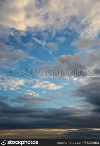 Beautiful dramatic sunset sky with dark clouds; vertical image