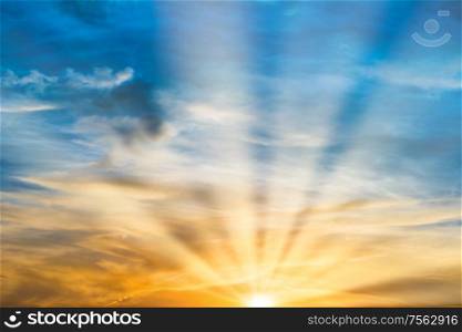 Beautiful dramatic sunset with sun rays and clouds