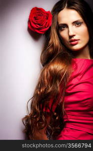 Beautiful dreaming girl with red roses in her hair