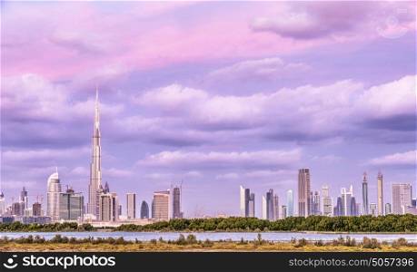 Beautiful Dubai cityscape, pink cloudy sky over luxury arabian town, futuristic modern buildings, expensive resort, travel and vacation concept