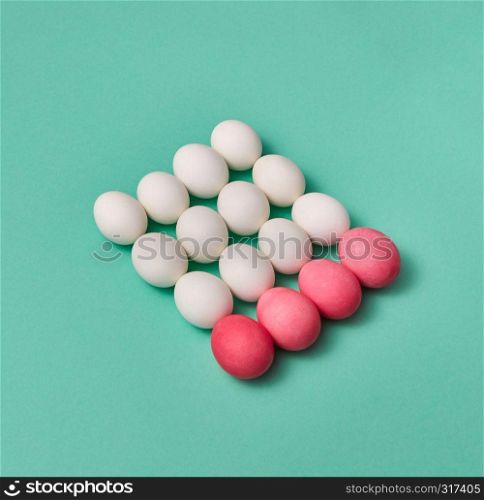 Beautiful Easter composition made of painted pink and white eggs on a green background with copy space. Creative layout for your ideas. Billiard game concept.. Set of white and pink colored eggs in the form of a square on a green background with copy space for text. Billiard balls concept