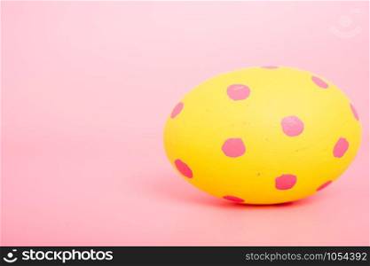 Beautiful Easter Yellow egg color on pink background, Easter day concept