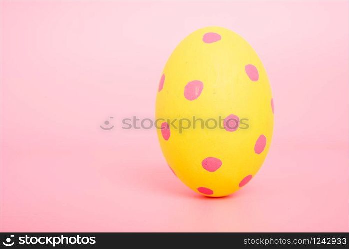 Beautiful Easter Yellow egg color on pink background, Easter day concept