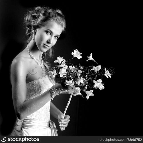 Beautiful, elegant bride in the original headdress, white retro style dress. Shooted against a black background. Has a copy space