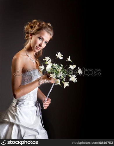 Beautiful, elegant bride in the original headdress, white retro style dress. Shooted against a black background. Has a copy space
