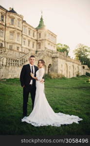 Beautiful elegant couple of newlyweds in love on the background of an old castle.. Beautiful elegant couple of newlyweds in love on the background of an old castle