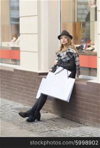 beautiful elegant woman , outdoor for shopping ,she is sitting on a window shop. she bring some bags with her