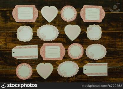 Beautiful empty gift cards with different shapes on a wooden background