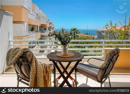 Beautiful empty private resort balcony with colorful flowers in a vibrant seaside setting - copy space. Beautiful empty private resort balcony with colorful flowers in a vibrant seaside setting