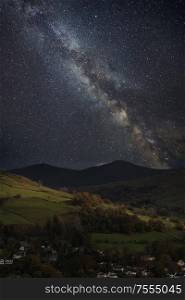 Beautiful epic digital composite landscape of Milky Way over Keswick in Lake District
