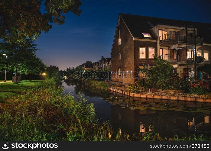 Beautiful evening in Netherlands. Lovely Dutch houses canal and pant reflections