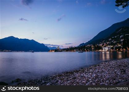 Beautiful evening scenery on the beach with cute little village, lago di garda, Italy.