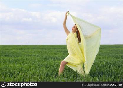 Beautiful expressive young woman in a green field